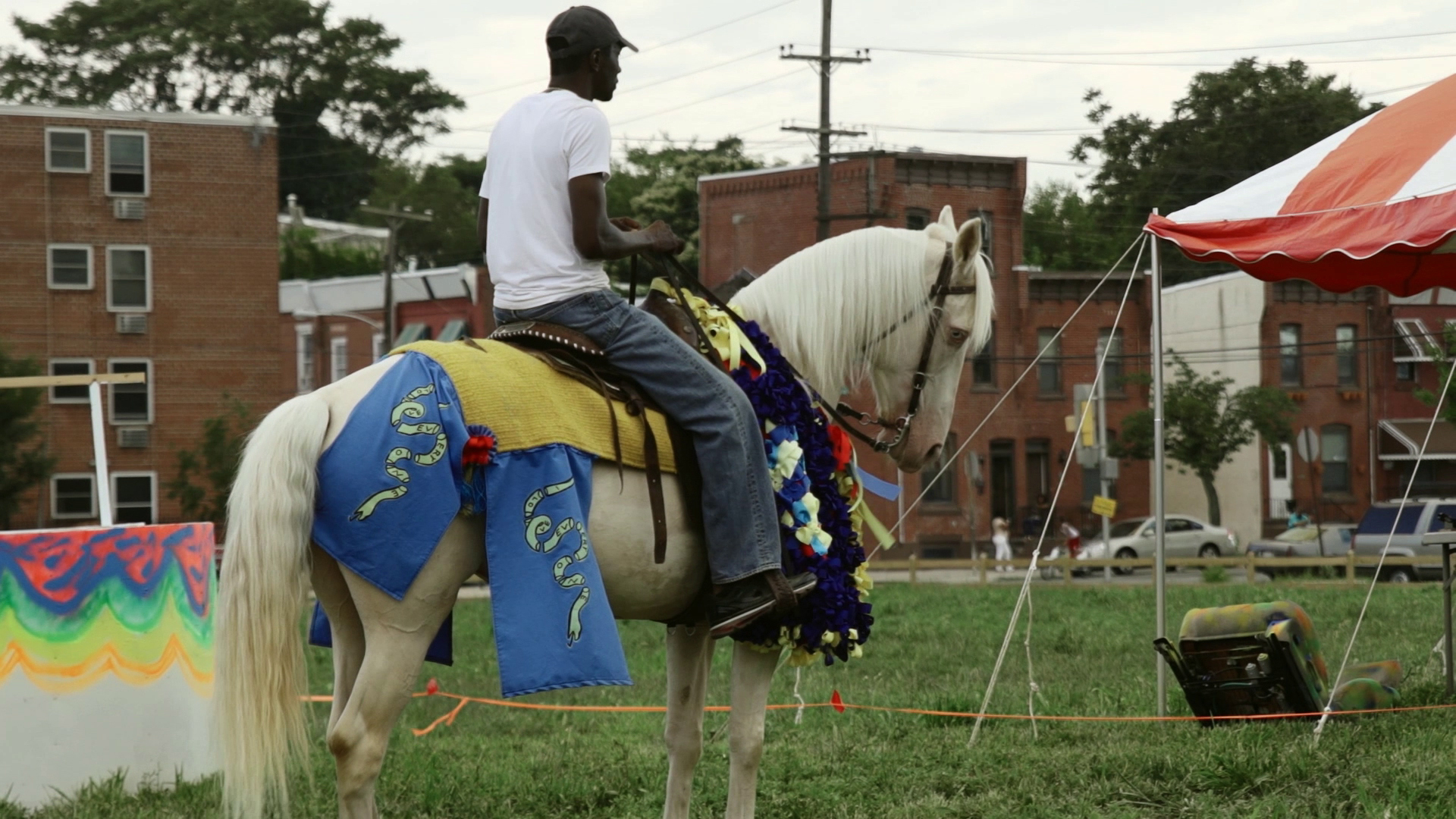 A rider sits atop a brightly costumed horse.