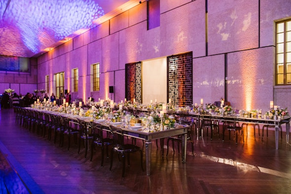 Rows of dinner tables line the court, topped with festive flowers.
