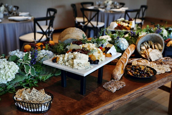 A table is topped with an attractive array of bread, olives, and fruit.