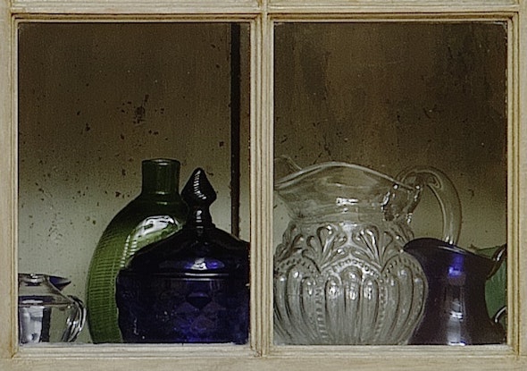 <p>A close look through the window of Braun’s cupboard reveals our mold-blown glass pitcher.</p>